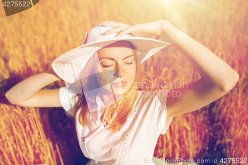 Image of happy young woman in sun hat on cereal field