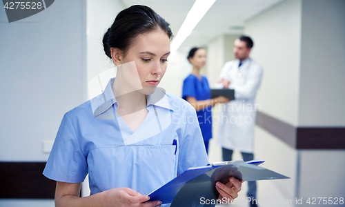 Image of female doctor or nurse with clipboard at hospital
