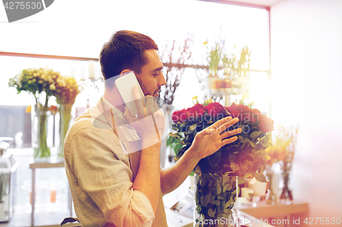 Image of man with smartphone and red roses at flower shop