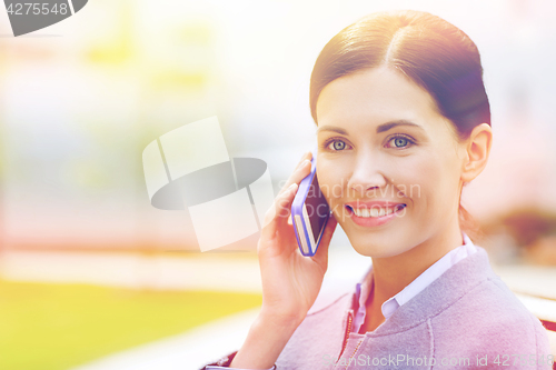 Image of young smiling businesswoman calling on smartphone