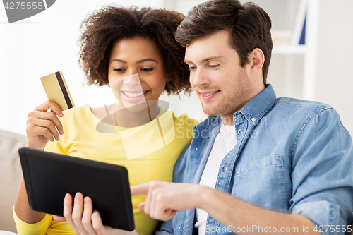 Image of couple with tablet pc and credit card at home