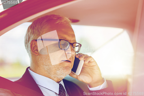 Image of senior businessman calling on smartphone in car