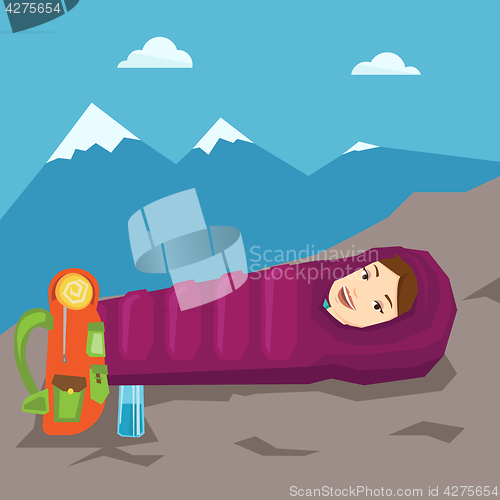 Image of Woman resting in sleeping bag in the mountains.