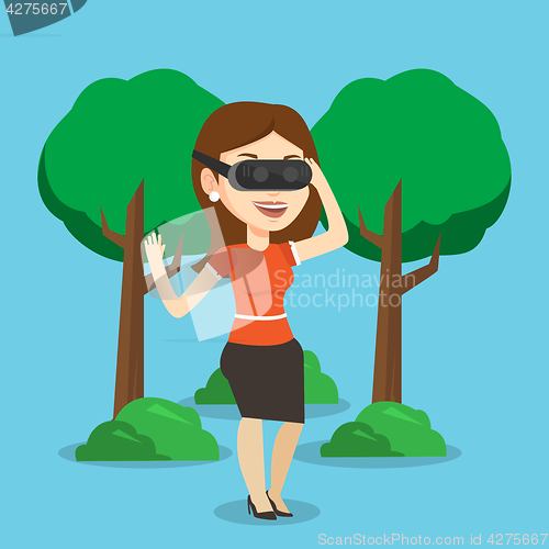 Image of Woman wearing virtual reality headset in the park.