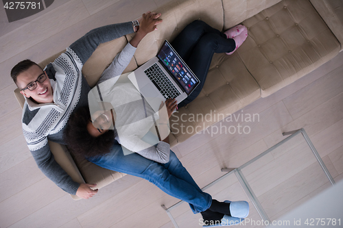 Image of happy multiethnic couple relaxes in the living room