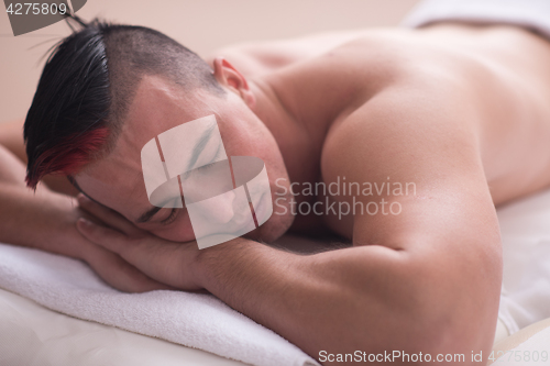 Image of handsome man resting in a spa massage center