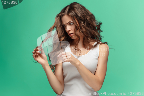 Image of Frustrated young woman having a bad hair on blue