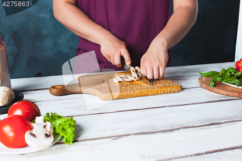 Image of Closeup hand of chef baker making pizza at kitchen