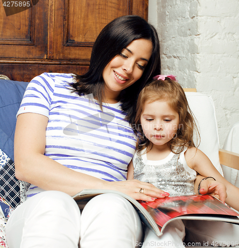 Image of young mother with little cute daughter on white, happy smiling family inside isolated adorable, lifestyle modern people concept