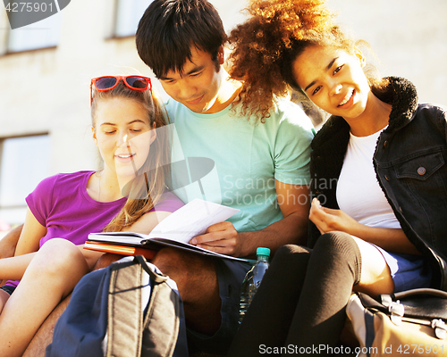 Image of cute group of teenages at the building of university with books 