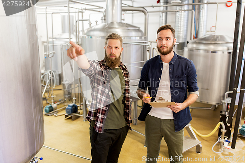 Image of men with clipboard at craft brewery or beer plant