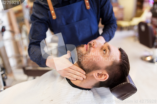 Image of barber applying aftershave lotion to male neck