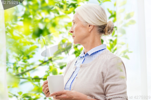 Image of lonely senior woman with cup of tea or coffee