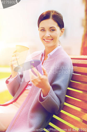 Image of smiling woman with coffee and smartphone