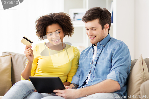 Image of couple with tablet pc and credit card at home