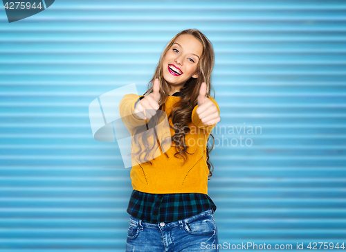 Image of happy young woman or teen girl showing thumbs up