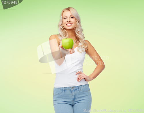 Image of happy beautiful young woman with green apple