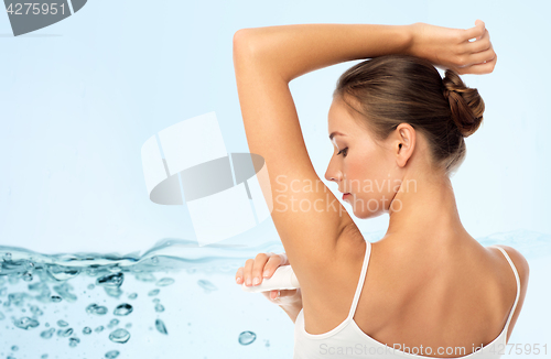 Image of woman with antiperspirant deodorant over blue