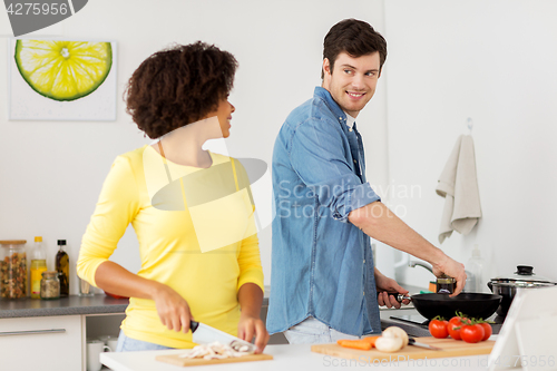 Image of happy couple cooking food at home kitchen