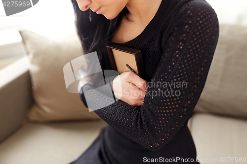 Image of woman with photo frame at funeral day