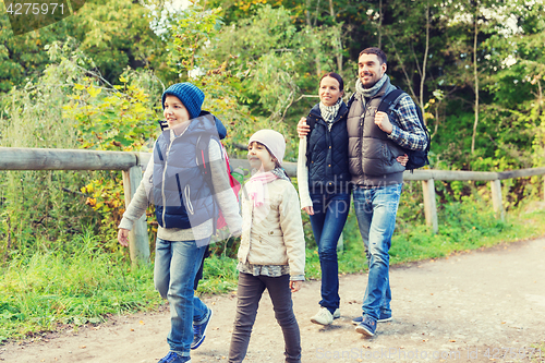 Image of happy family with backpacks hiking in woods