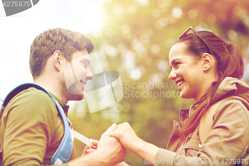 Image of happy couple with backpacks hiking outdoors