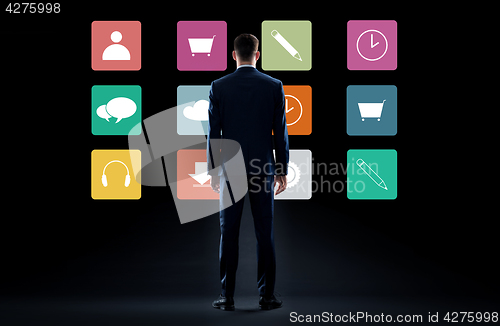 Image of businessman in suit looking at virtual menu icons