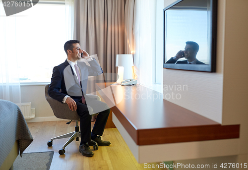 Image of businessman calling on smartphone at hotel room