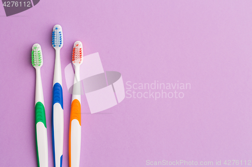 Image of Photo of three colored toothbrushes