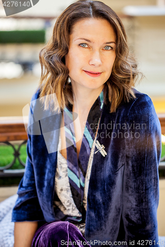 Image of woman in purple jacket with dragonfly brooch