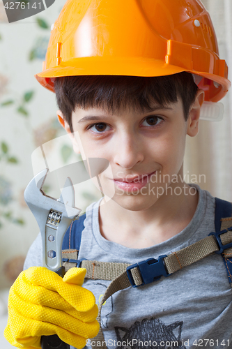 Image of Boy in a protective helmet and with a wrenc