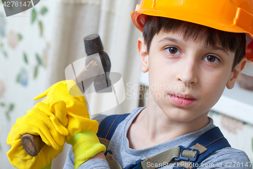 Image of boy in a protective helmet and with a hammer 