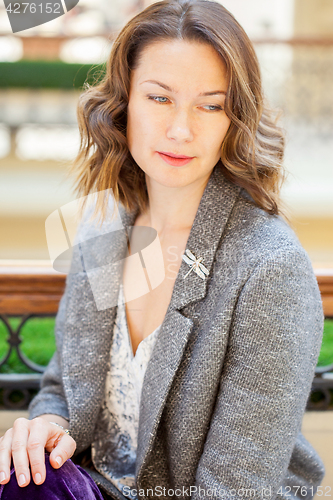 Image of woman in gray jacket with dragonfly brooch