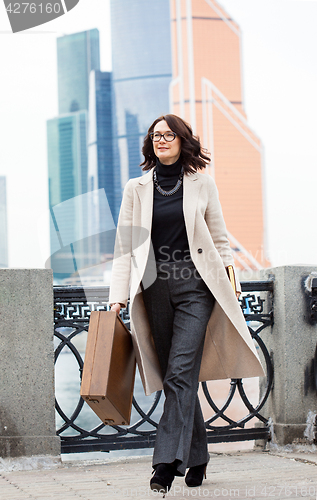 Image of Beautiful businesswoman in a light coat