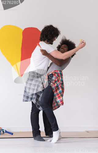 Image of couple with painted heart on wall