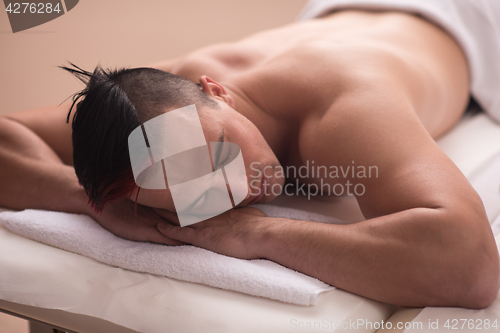 Image of handsome man resting in a spa massage center