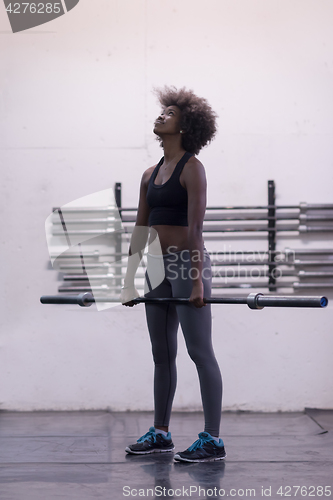 Image of black woman lifting empty bar