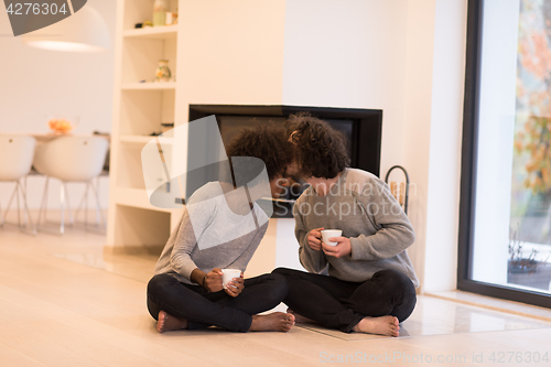 Image of multiethnic couple  in front of fireplace