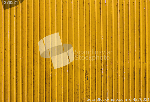 Image of old yellow painted metal ribbed surface