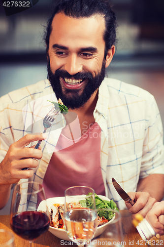 Image of happy man having dinner at restaurant
