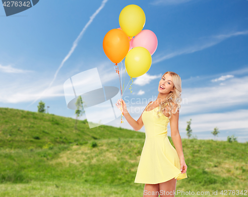 Image of happy woman with helium air balloons in summer