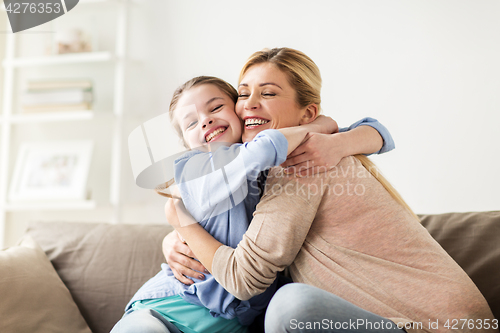 Image of happy smiling family hugging on sofa at home