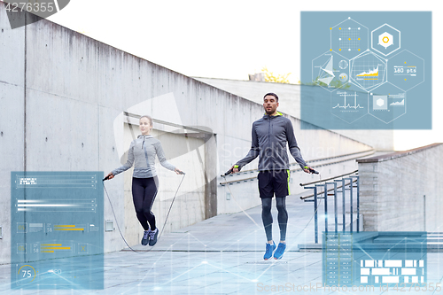 Image of man and woman exercising with jump-rope outdoors