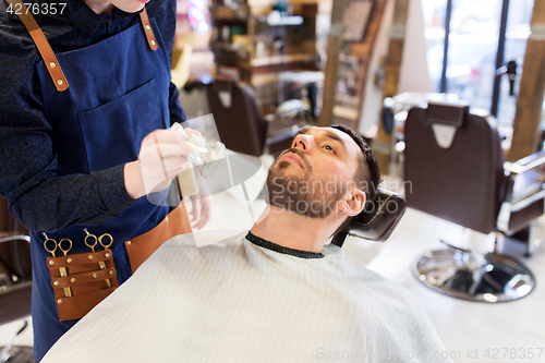 Image of barber cleaning male face with brush at barbershop