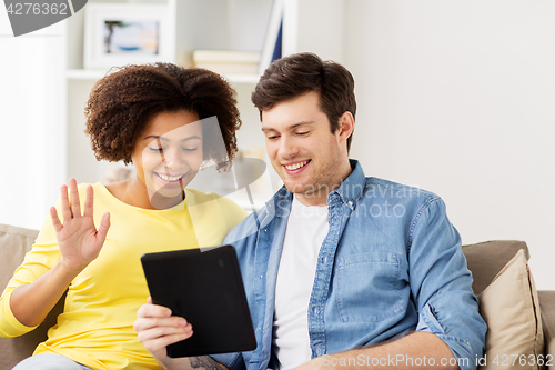 Image of smiling happy couple with tablet pc at home