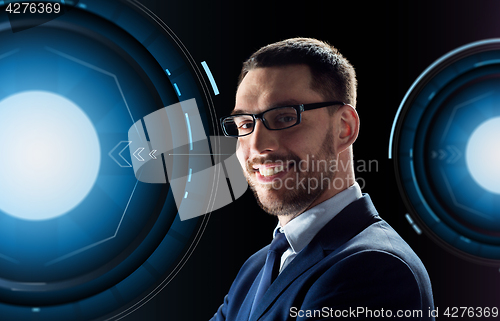 Image of smiling businessman in glasses over black