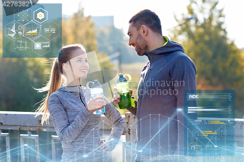 Image of smiling couple with bottles of water outdoors