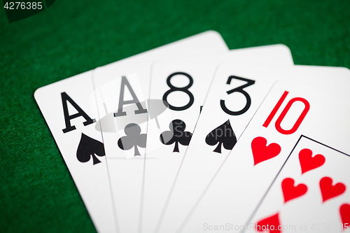 Image of poker hand of playing cards on green casino cloth