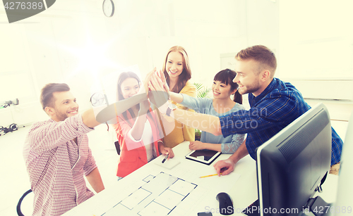 Image of creative team making high five at office