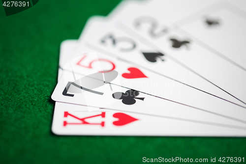 Image of poker hand of playing cards on green casino cloth